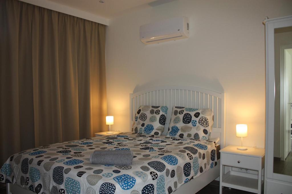 a bedroom with a bed with pillows and two lamps at Blije Rust in Blue Bay