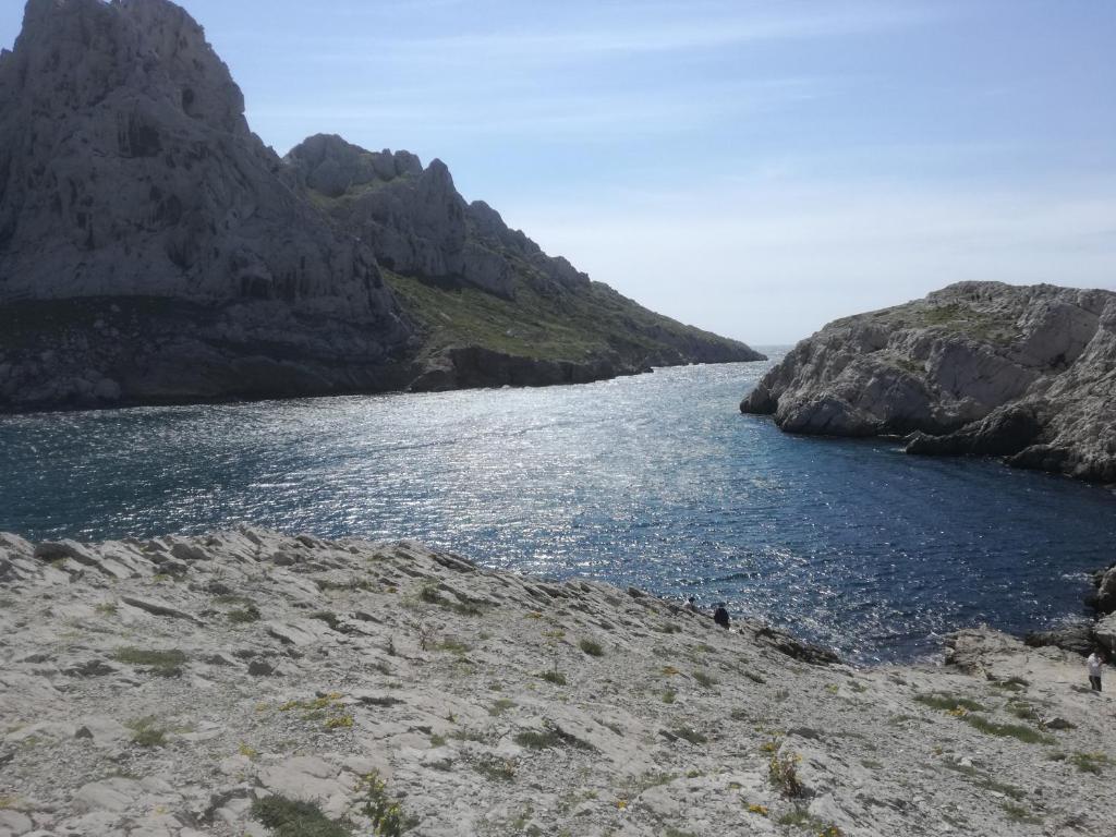 a large body of water next to a mountain at "Lou Pataquet" in Marseille