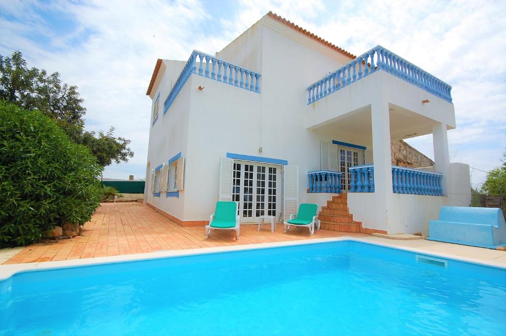 a villa with a swimming pool in front of a house at Casa da Eira - Private Villa - pool - Free wi-fi - Air Con in Silves