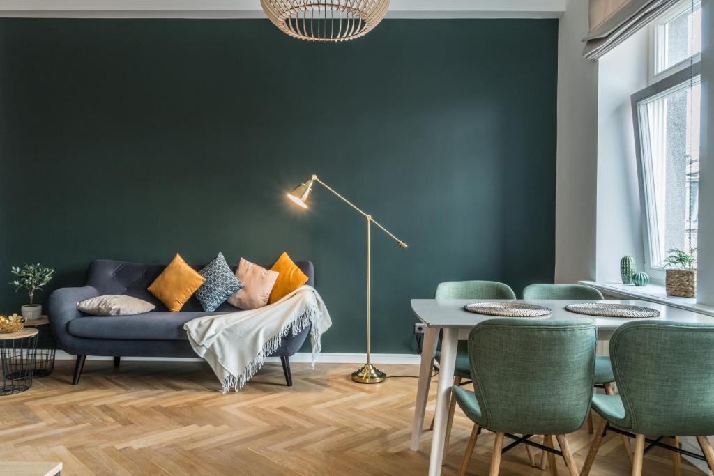 a living room with a blue couch and a table at Greystone Suites & Apartments in Rīga