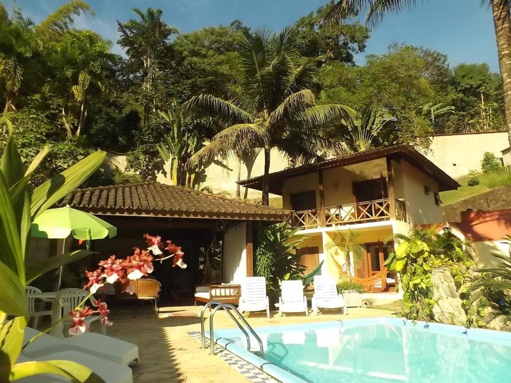 a resort with a swimming pool and a house at Castelinho de Paraty in Paraty