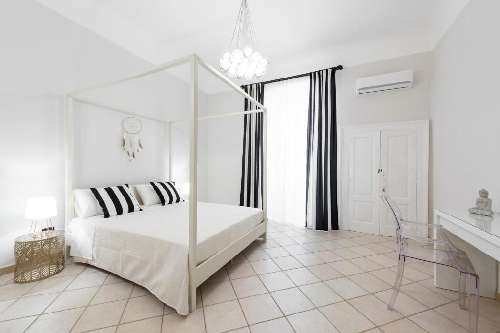 a white bedroom with a bed with a glass canopy at Ancient Maison M8 Bari in Bari