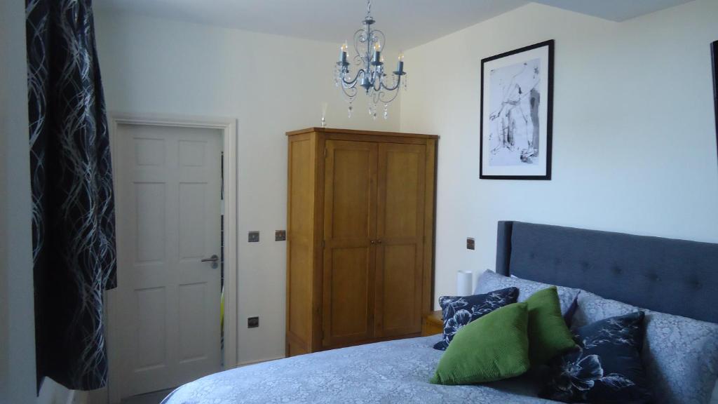 a bedroom with a bed and a chandelier at Hunter’s Retreat in York