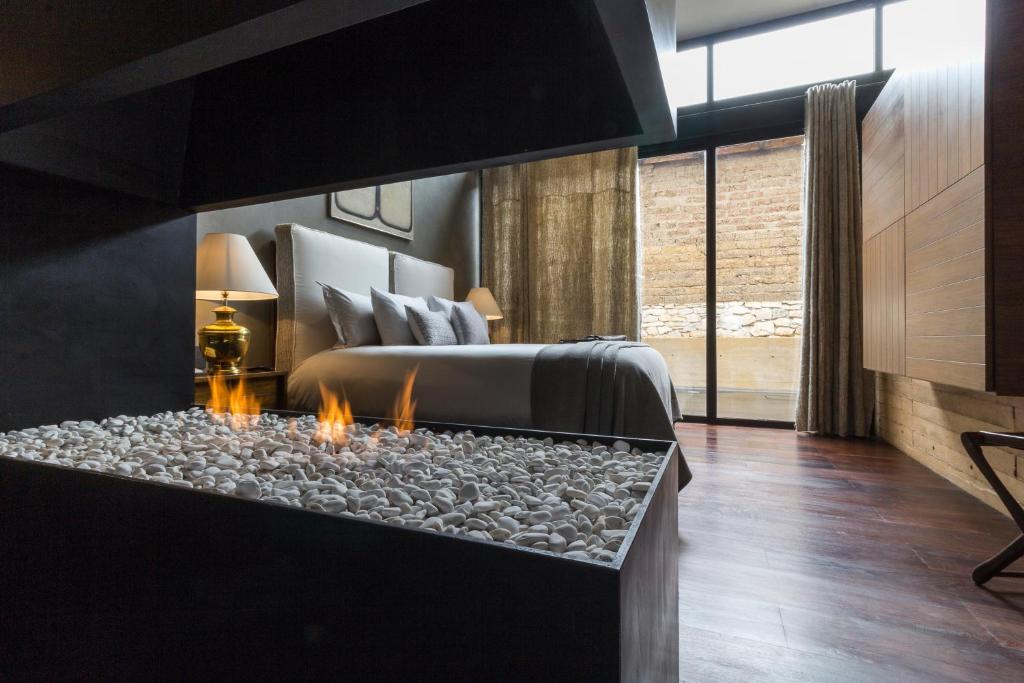 a bedroom with a bed and a fire place at Uvence Arte + Hotel in San Cristóbal de Las Casas