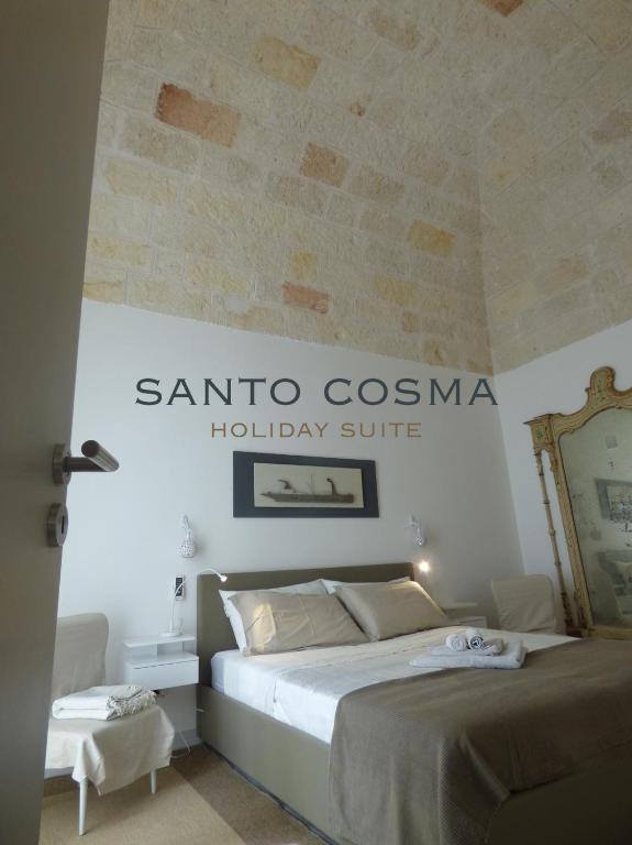 a bedroom with a bed with a santa cosuna holiday suite sign at WePuglia - Santo Cosma - La Suite in Polignano a Mare