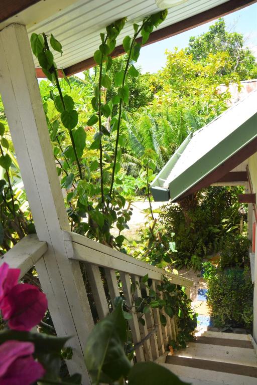 a porch with a white railing and some flowers at Fare Maheata in Pihaena