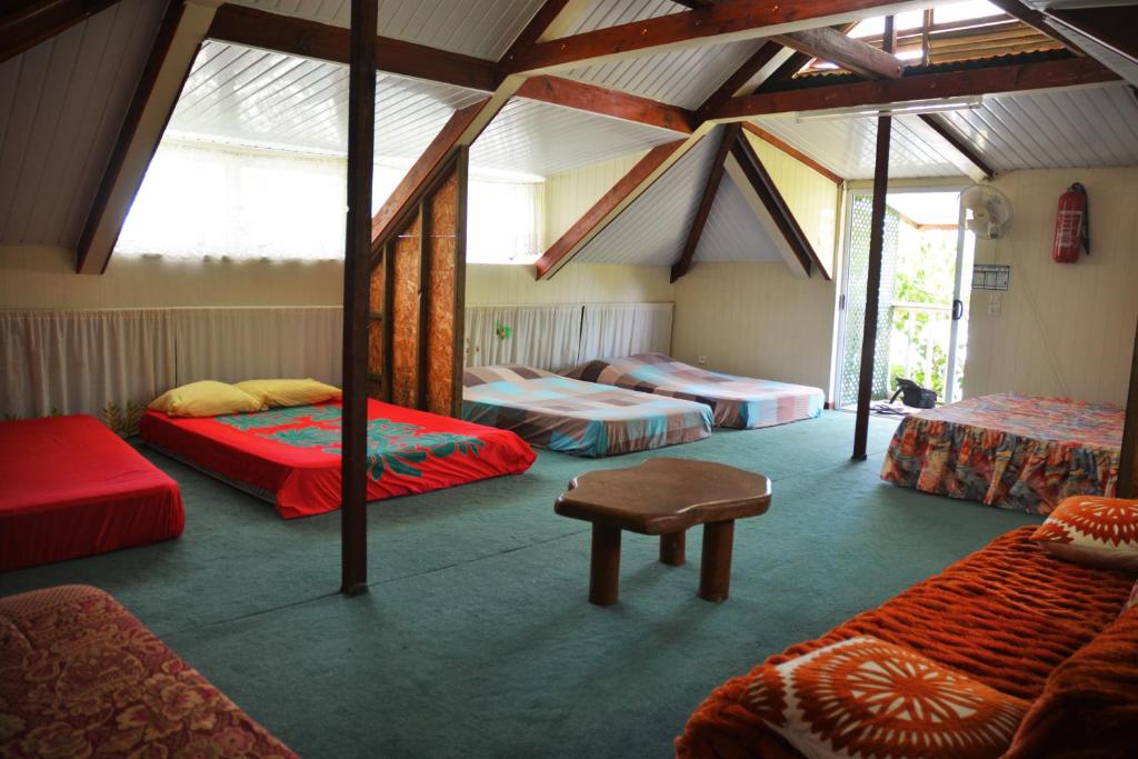 a room with four beds and a table in it at Fare Maheata in Pihaena