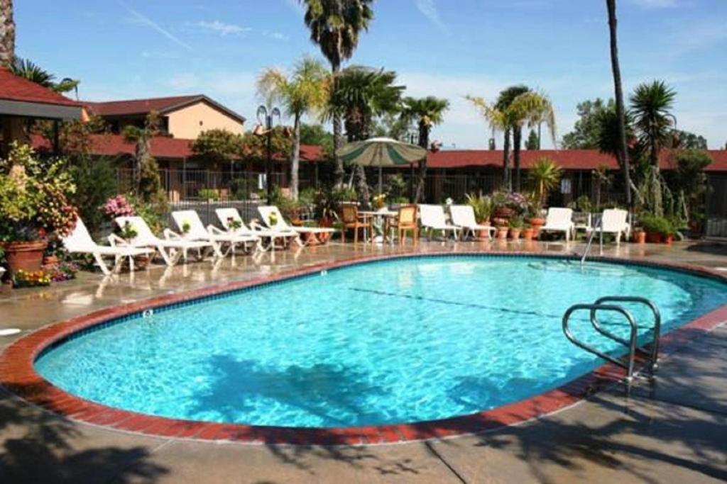 a large swimming pool with chairs and a table at Adelaide Inn in Paso Robles