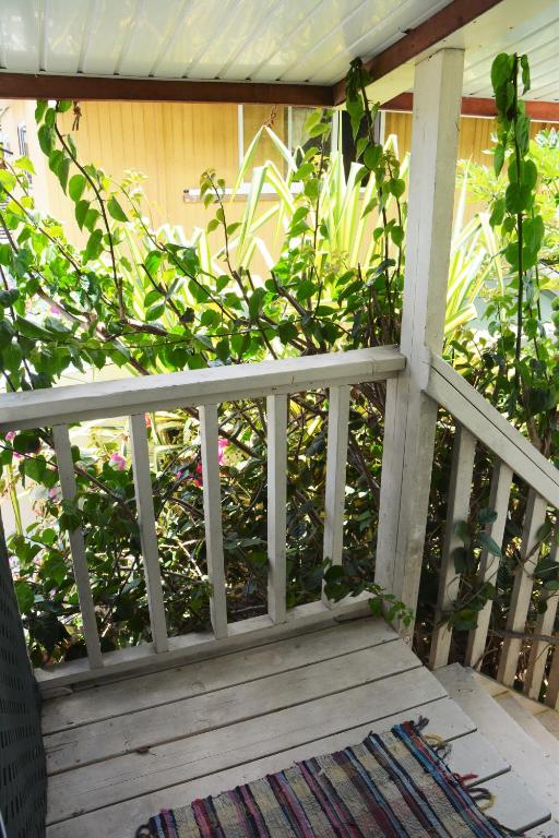 a porch with a white fence and a rug at Fare Maheata in Pihaena