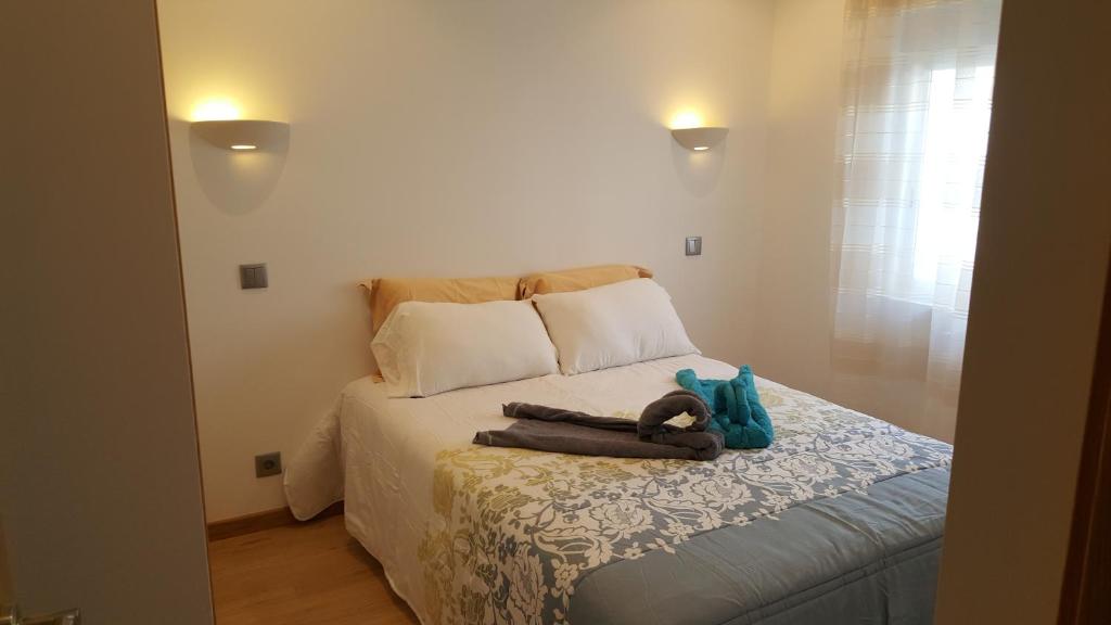 a bedroom with a bed with a stuffed animal on it at Apartamento Cardoso II. A 5 minuto a pé da praia do Peneco in Albufeira
