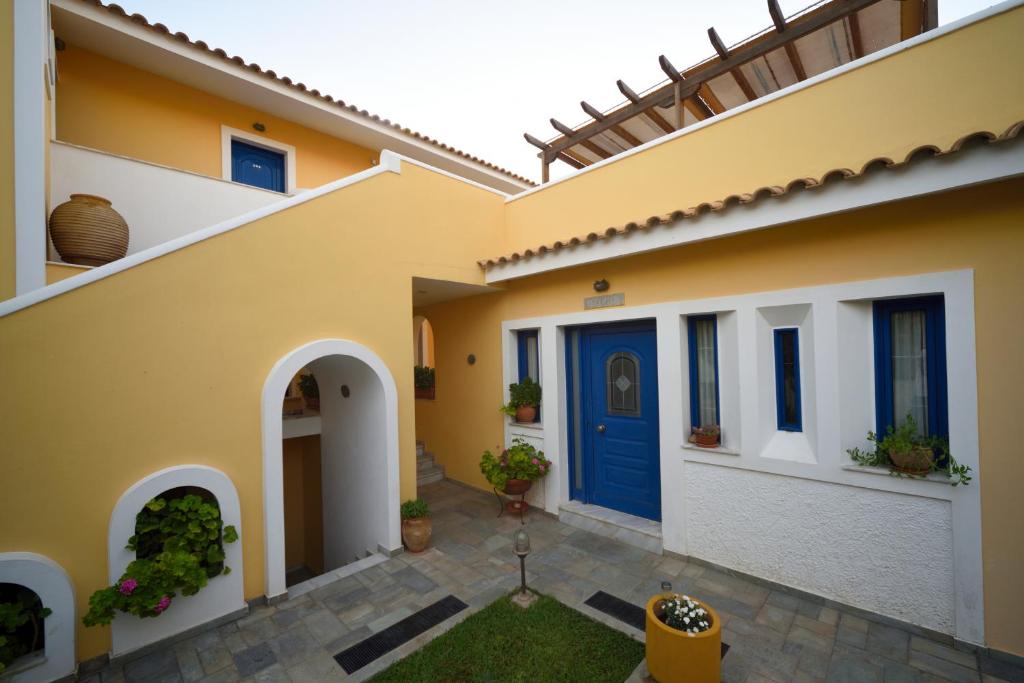 a house with a blue door and a courtyard at Hotel Palazzo in Archangelos