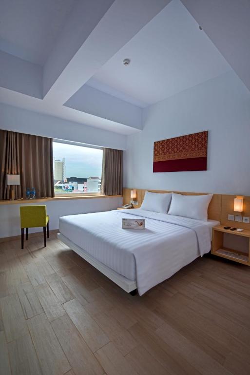 Postel nebo postele na pokoji v ubytování Whiz Prime Hotel Sudirman Pekanbaru