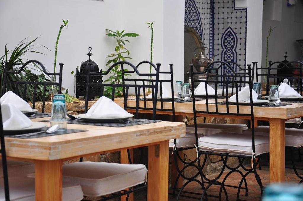 a group of tables and chairs in a room at Hotel Al Alba Hammam & Restaurant in Asilah