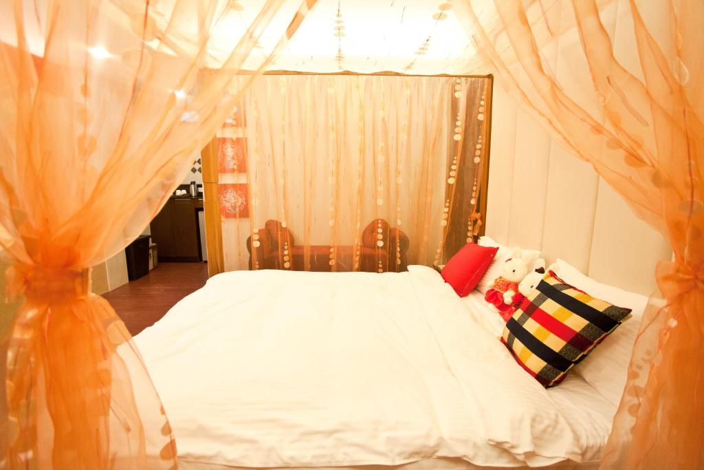 a bedroom with a white bed with a canopy at Li Wu Zuo Cun B&amp;B in Chongde