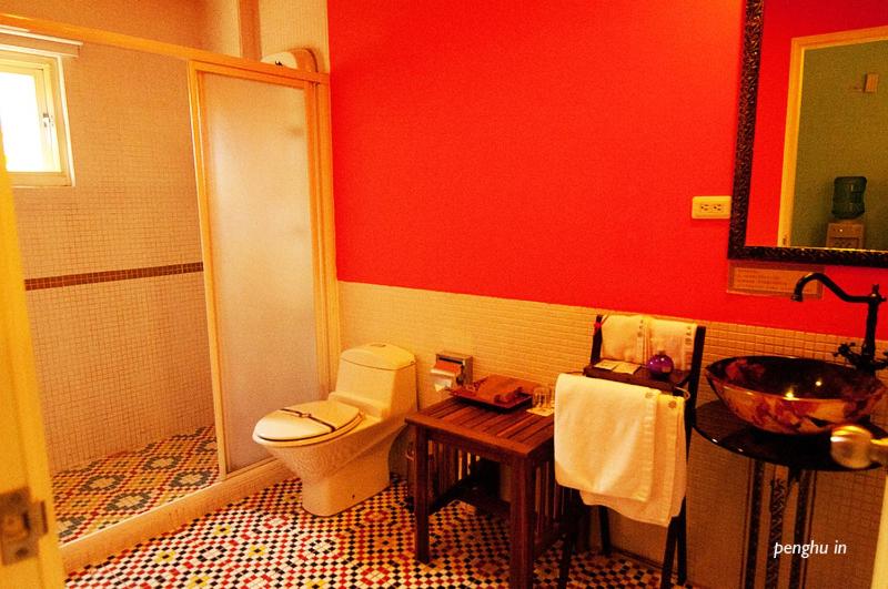 a red bathroom with a toilet and a sink at Raid Garden Boutique Hotel in Magong