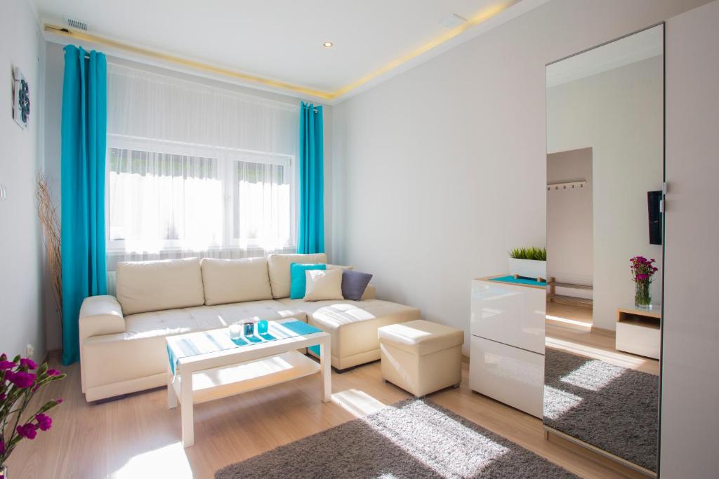 a living room with a white couch and a table at Sopot City Apartment in Sopot