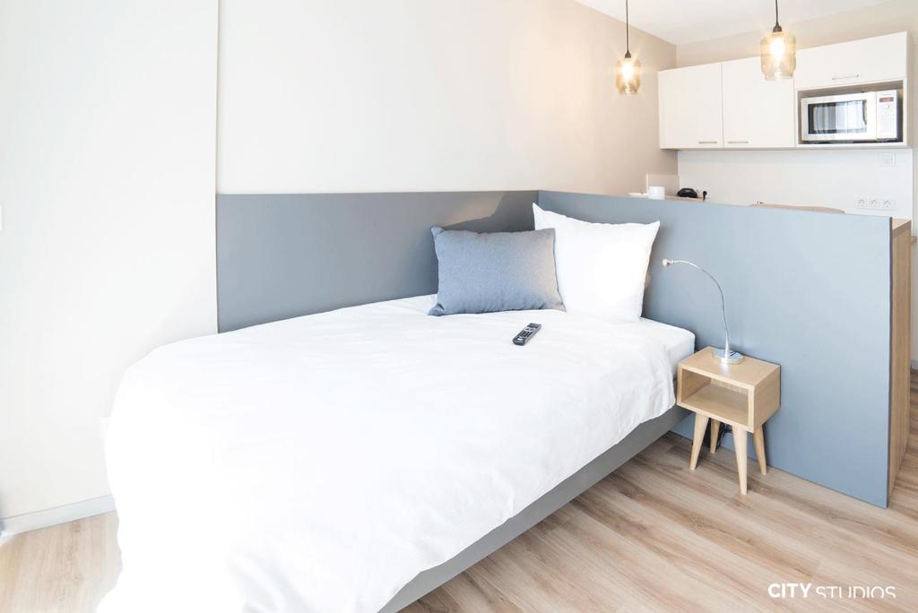 1 dormitorio con 1 cama grande y pared azul en City Studios, en Heidenheim an der Brenz