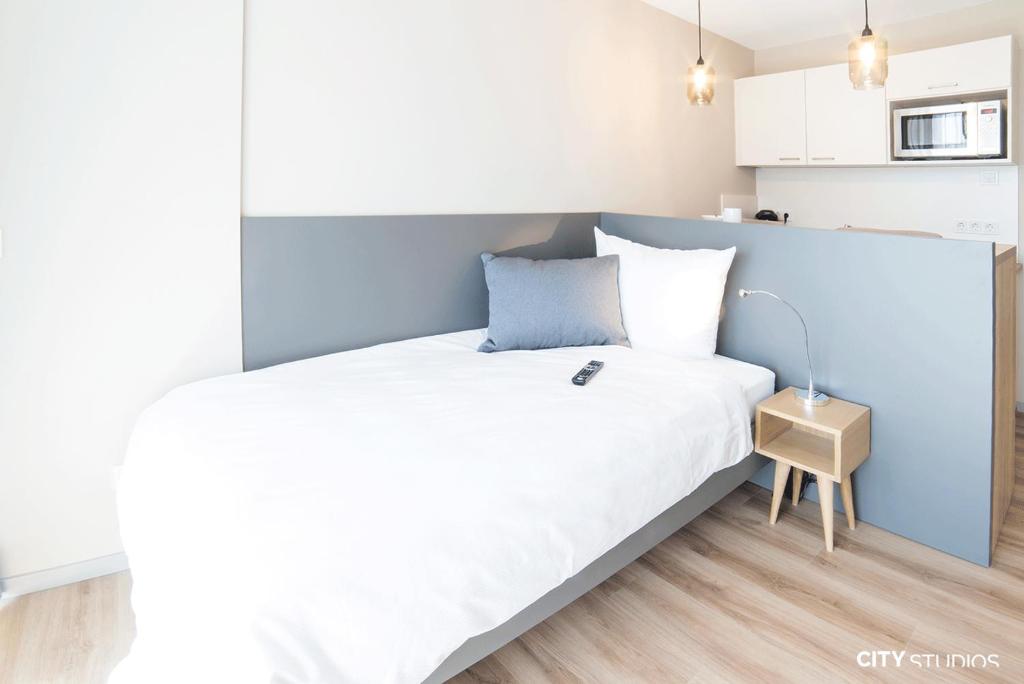 Un dormitorio con una cama grande con una pared azul. en City Studios, en Heidenheim an der Brenz