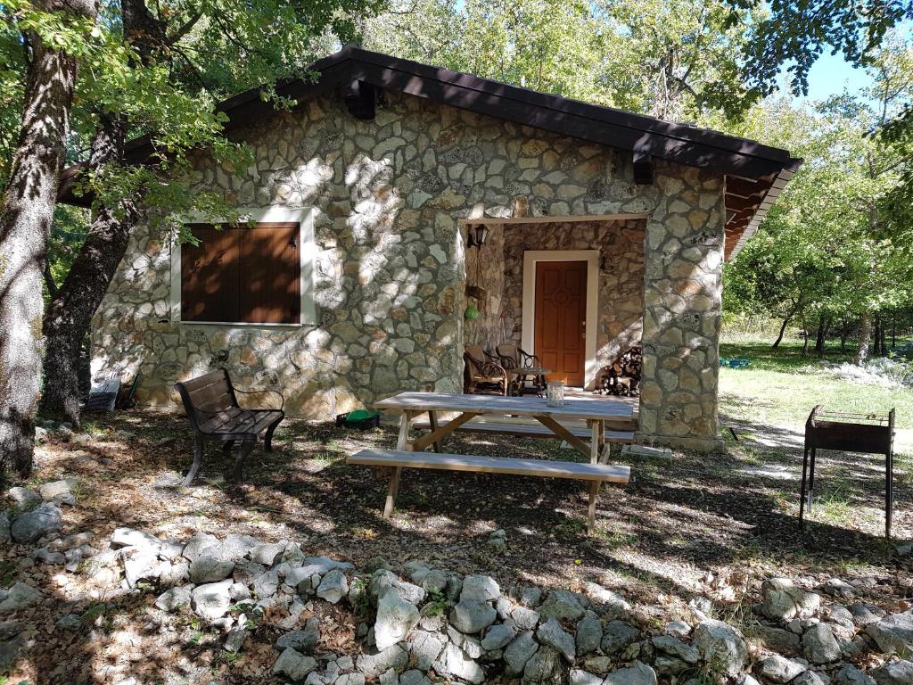 a stone cabin with a picnic table in front of it at Il Rifugio dei Briganti in Caramanico Terme