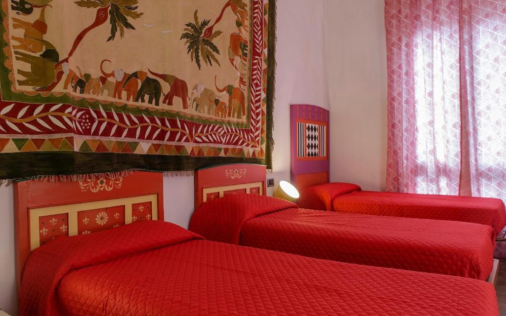 a room with four red beds in a room at University beb bologna in Bologna