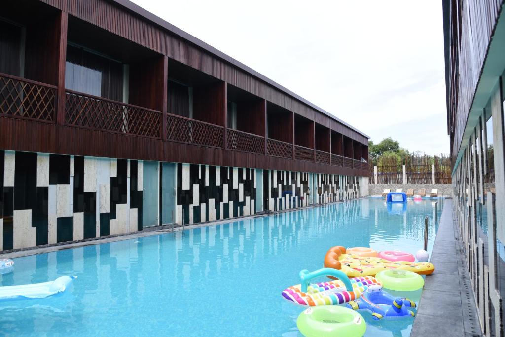 a swimming pool with inflatables in front of a building at Haywizz Havelock Island Resort in Havelock Island
