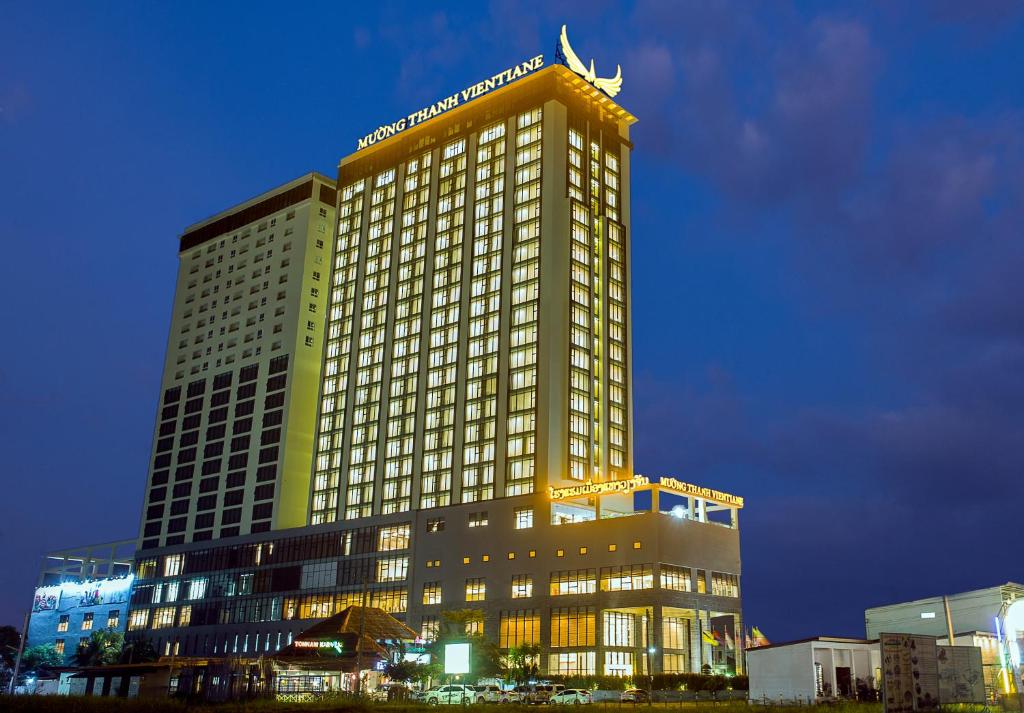 un edificio alto con luces encendidas por la noche en Muong Thanh Luxury Vientiane Hotel, en Vientiane