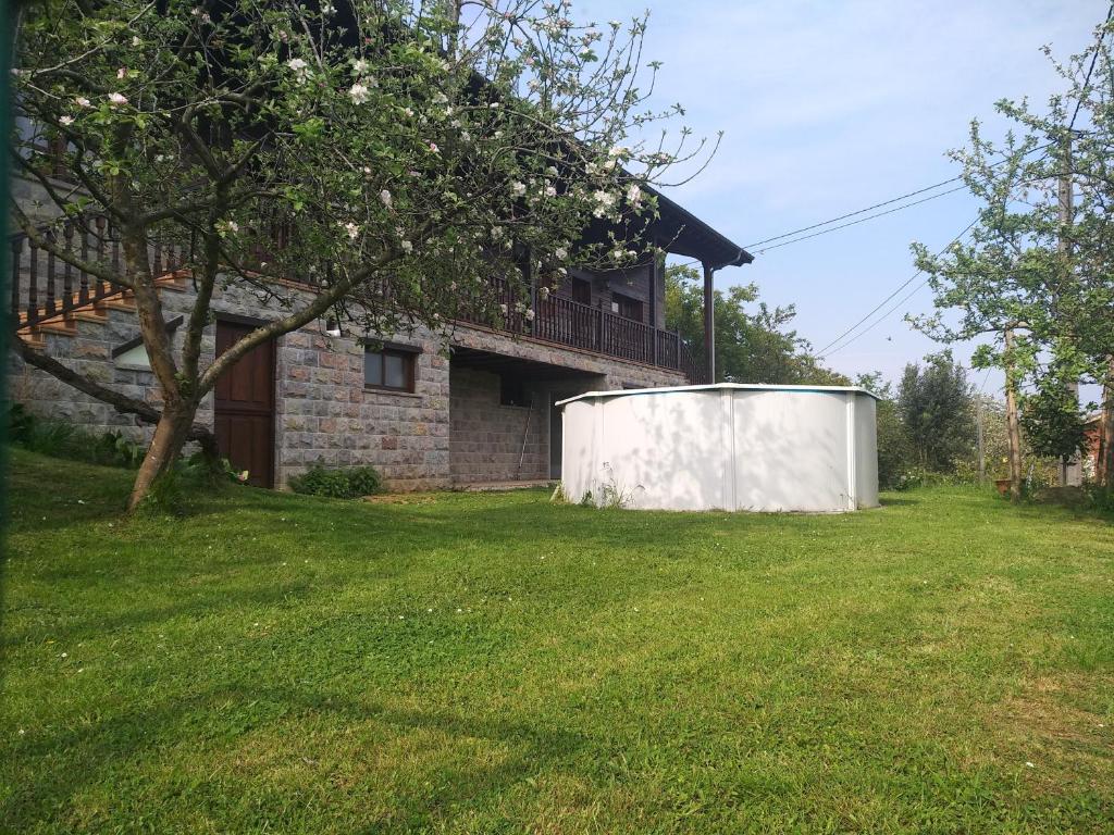 una casa con un gran patio junto a un edificio en Viviendas vacacionales La Casona de Tresniñin en Nava