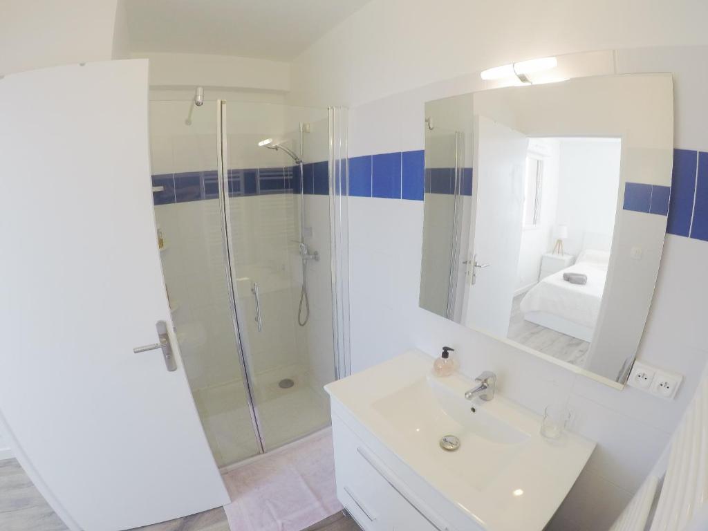 a white bathroom with a shower and a sink at Appartement Ajaccio vue mer panoramique in Ajaccio