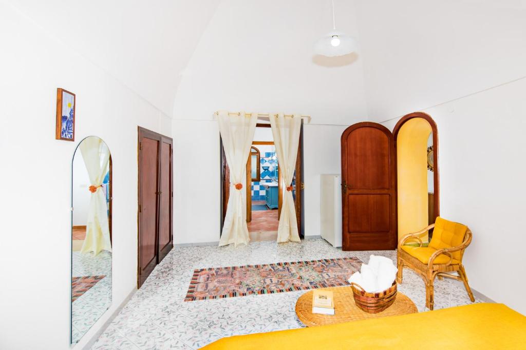 sypialnia z łóżkiem i żółtym krzesłem w obiekcie YourHome - Casa Sansone Positano w mieście Positano