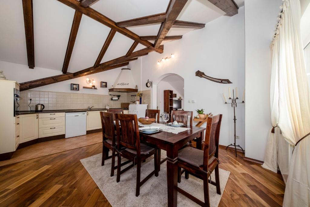 uma cozinha e sala de jantar com uma mesa de madeira e cadeiras em Apartmani Godinić em Rab