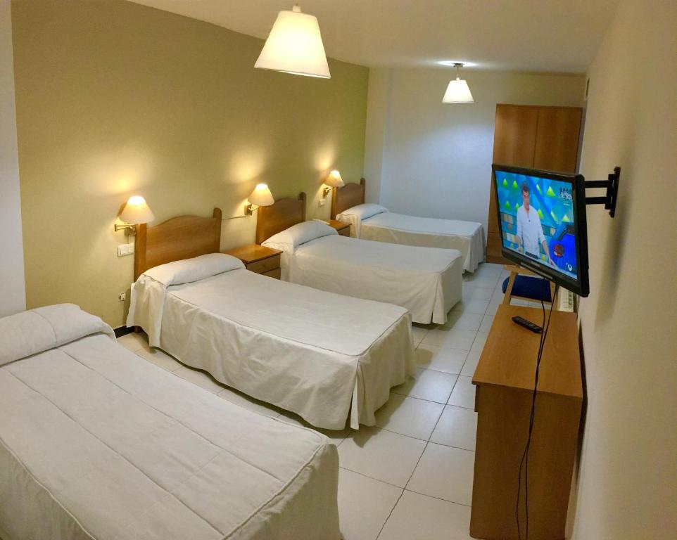 En eller flere senge i et værelse på Hotel El Emigrante