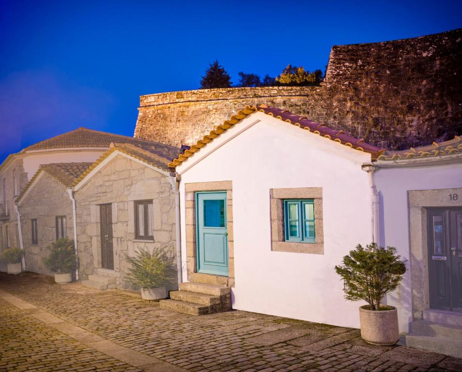 a row of white houses with a blue door at Casa do Cais Cerveira in Vila Nova de Cerveira