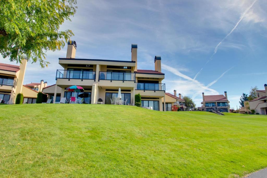 ein großes Haus auf einem Grashügel in der Unterkunft Lake Chelan Shores in Chelan