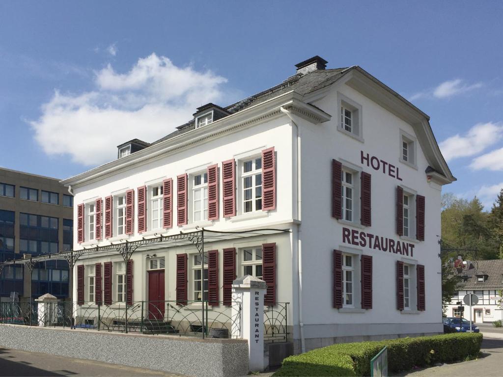 a white building with red shutters on a street at Alte Rentei in Schleiden