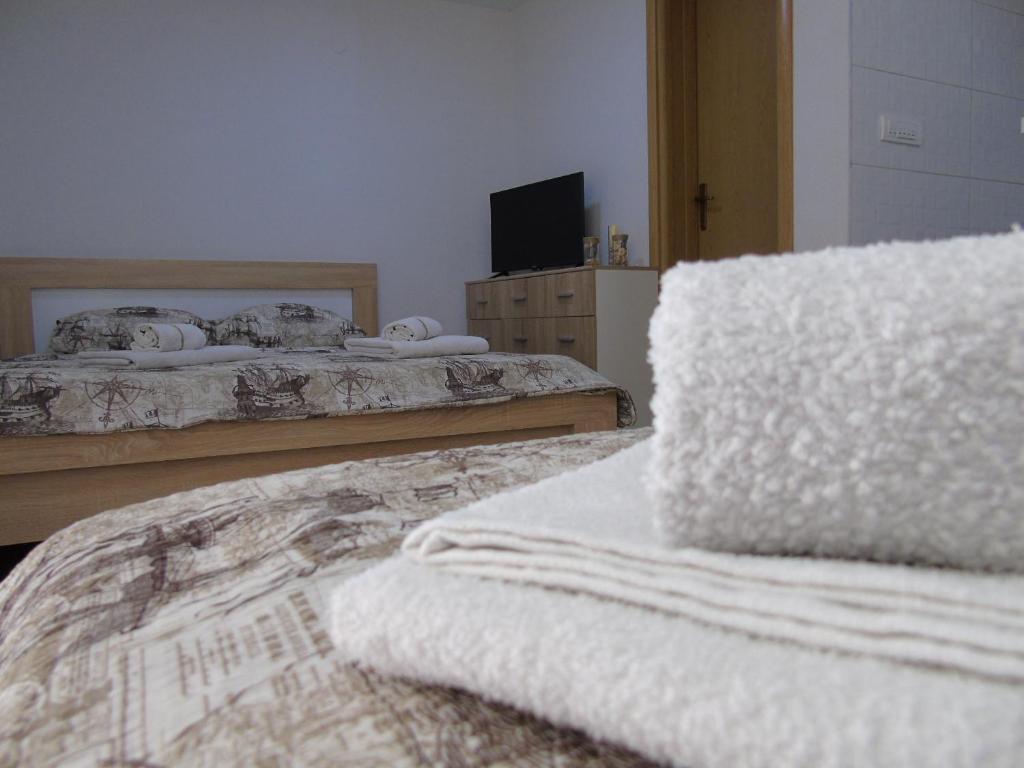 a bedroom with two beds with white blankets on them at Apartments Marysol in Kotor
