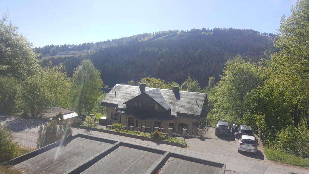 an aerial view of a house with cars parked in a parking lot at Haus Vor den Eichen für Familien in Willingen