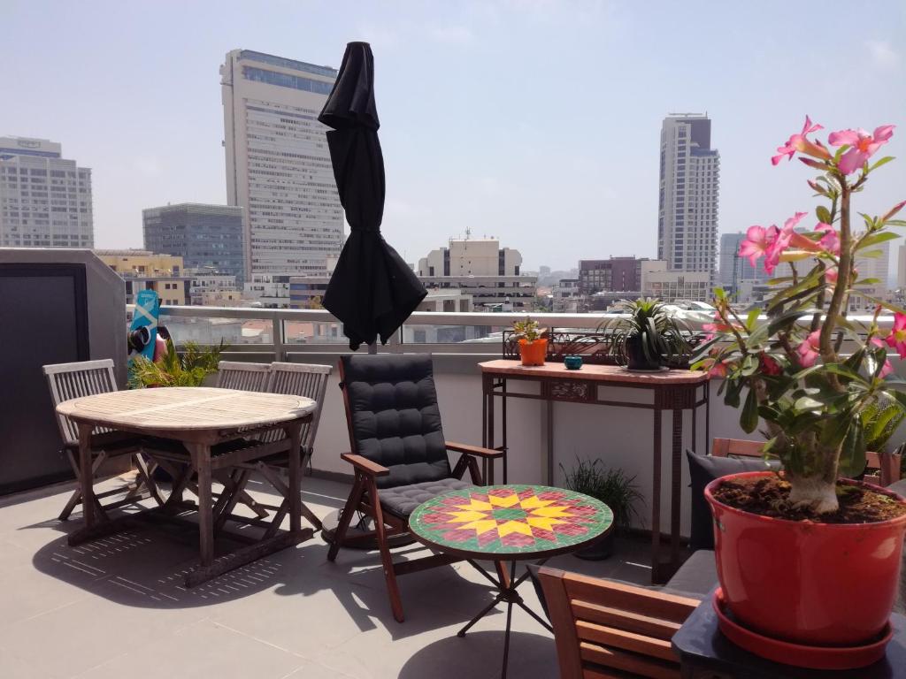 a balcony with a table and chairs and an umbrella at DUPLEX TERRACES TEL AVIV. in Tel Aviv