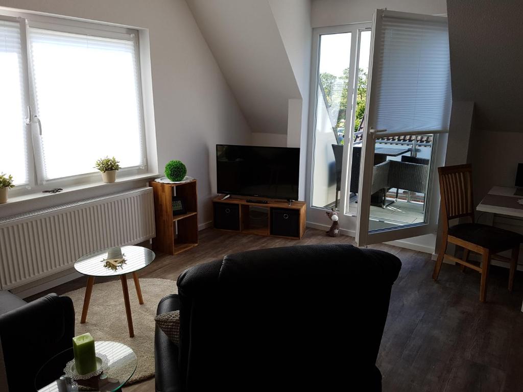 ein Wohnzimmer mit einem Sofa und einem TV in der Unterkunft Haus Weimann in Büsum