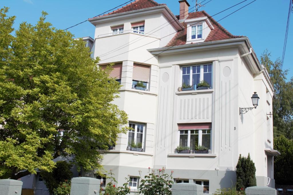 une maison blanche avec un toit rouge dans l'établissement La Chambre de Marie, à Bouxwiller