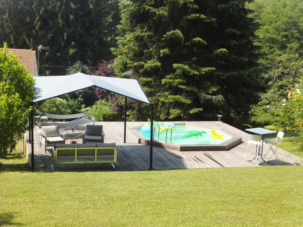 - une piscine avec un parasol, une table et des chaises dans l'établissement L'Eugenie, à Pierrefonds