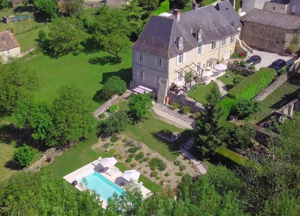 einen Luftblick auf ein großes Haus mit einem Pool in der Unterkunft Chambre d'hôtes Au jardin de la Bachellerie in La Bachellerie