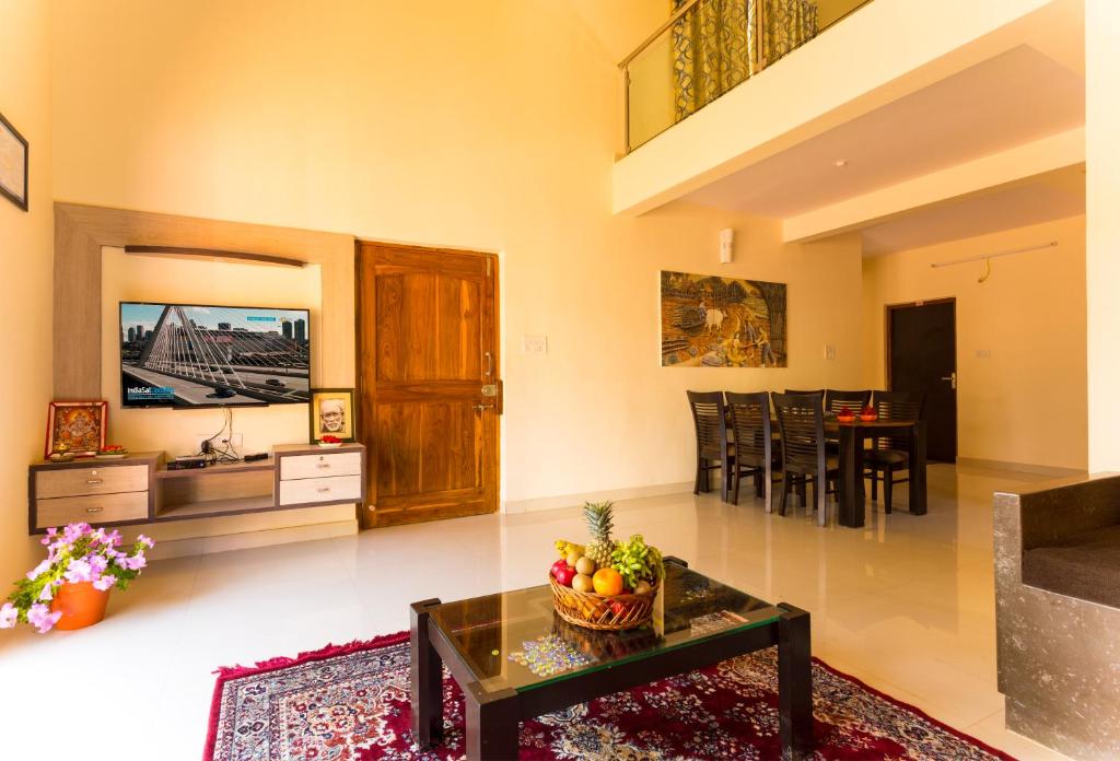 ein Wohnzimmer mit einem Tisch und einem Esszimmer in der Unterkunft Shri Laxmi Narayan Bungalow in Mahabaleshwar