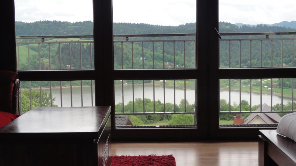 a room with a view of a river from a window at Wilkowka in Wołkowyja
