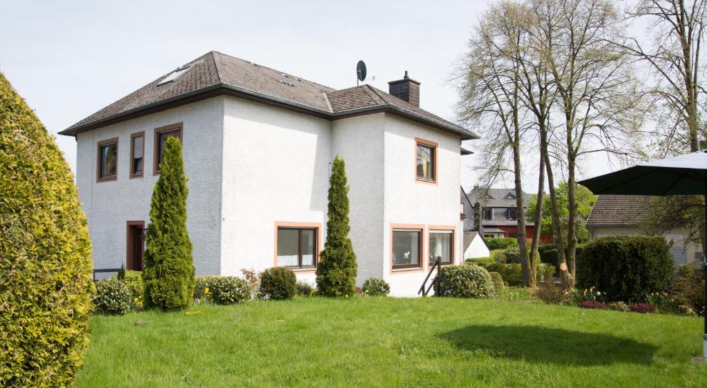 una casa blanca con un patio verde en Altes Forsthaus, en Manderscheid
