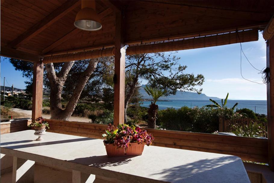 a porch with a table with a view of the ocean at CASA CON VERANDE SUL MARE a 2 MINUTI A PIEDI DALLA SPIAGGIA in Custonaci
