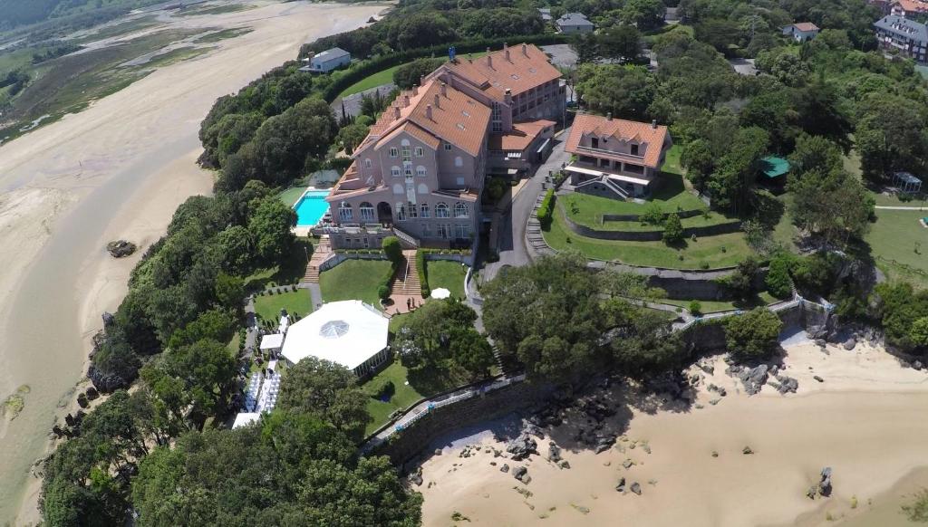 an aerial view of a large house on the beach at Hotel Olimpo in Isla
