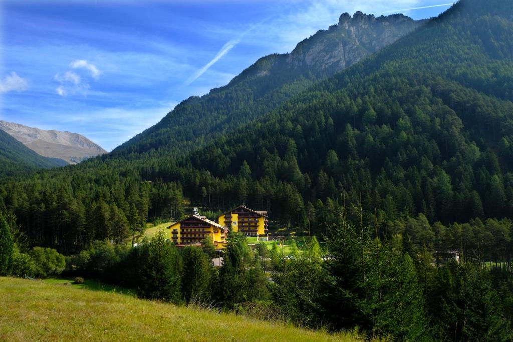 a house in the middle of a mountain at Hotel Shandranj in Tesero