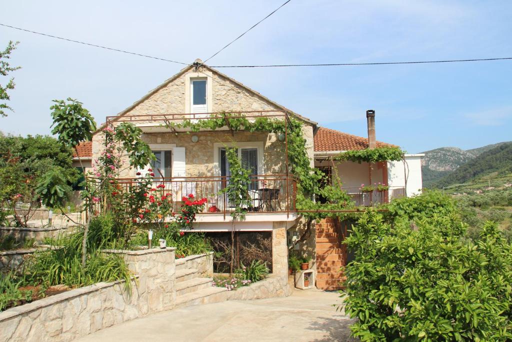 ein Haus mit Balkon auf einem Hügel in der Unterkunft Apartmani Ivanković in Vrisnik