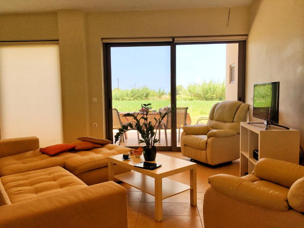 ein Wohnzimmer mit Sofas, Stühlen und einem Tisch in der Unterkunft Stellar Beachhouse in Gerani Chania