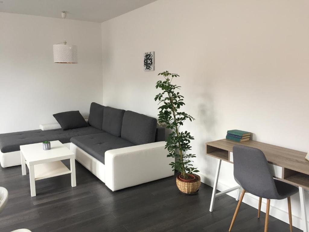 salon z czarno-białą kanapą i stołem w obiekcie Rozmaring Apartman Pécs w mieście Pecz